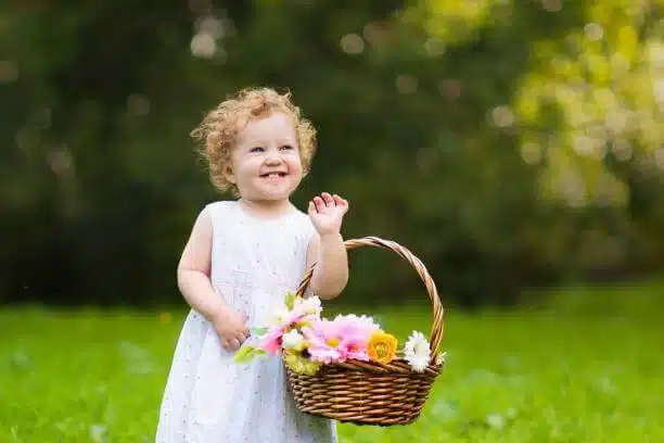 صورة لبنت صغيرة تمسك سلة زهور